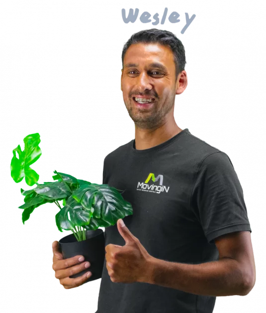 Wesley holding a plant while giving a thumbs up