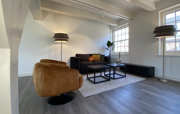 Cozy living room with a comfortable couch, stylish chair, and elegant table